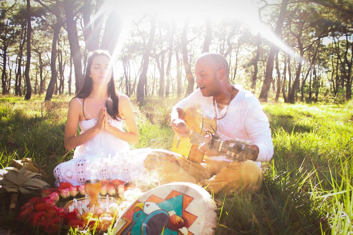 German Virguez and Lupita Castro in meditation before a ceremonial altar in a forest clearing